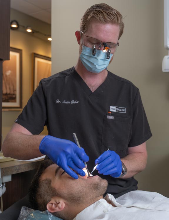 Dr. Austin examining a make patient in an exam chair